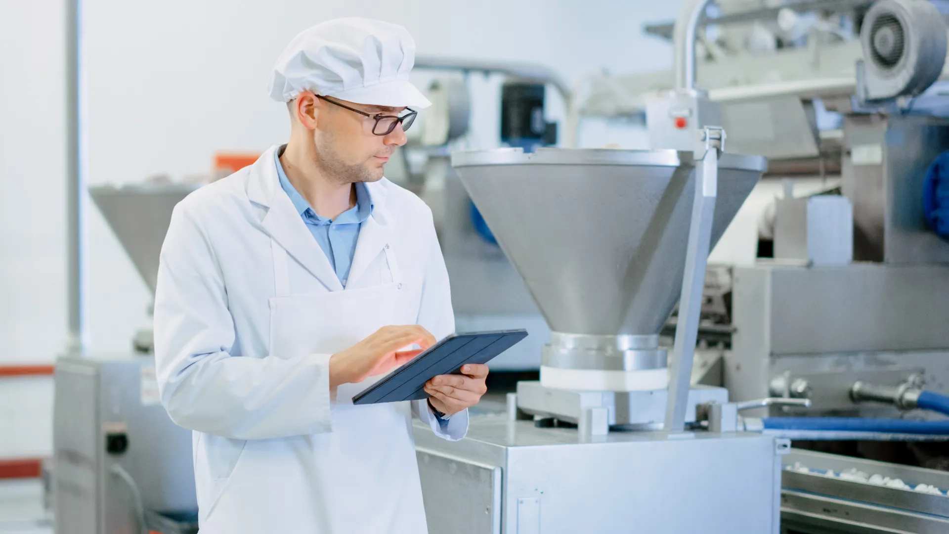 Young Male Quality Supervisor or Food Technician is Inspecting the Automated Production at a Food Factory. 
