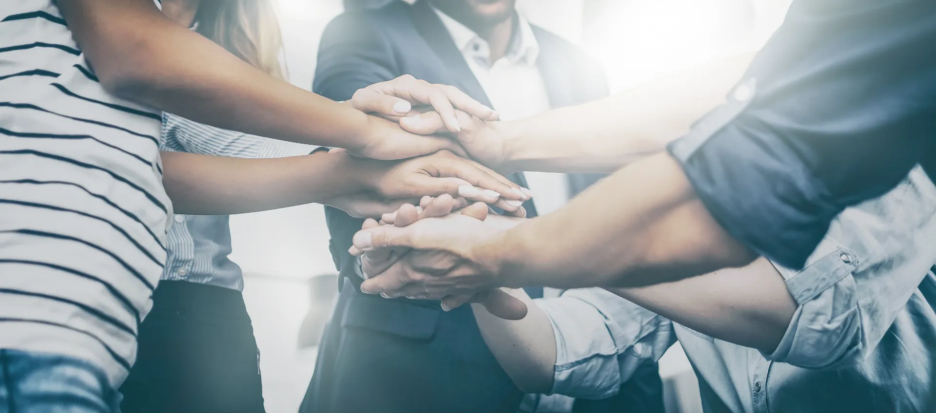Team places their hands on top of each other as a sign of solidarity and cooperation.